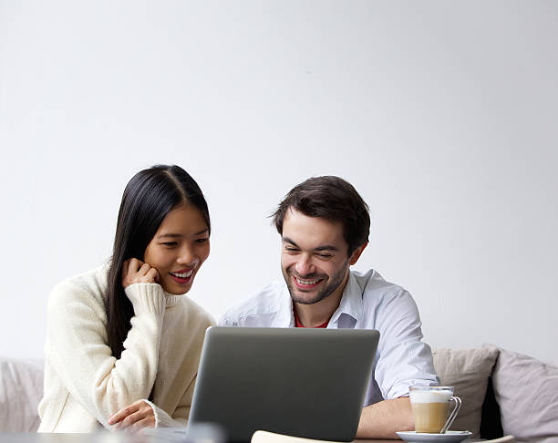 Happy young couple working on laptop at home