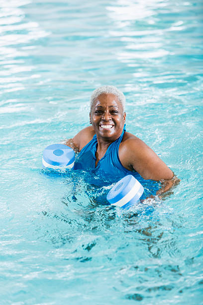 istock Senior black woman exercising, doing water aerobics 531241095