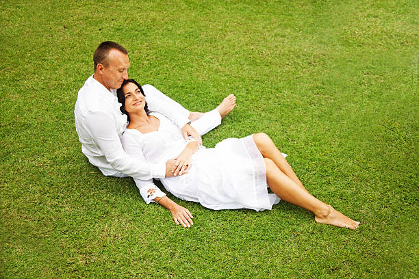 istock Bride and groom sitting on the grass 531242583