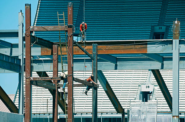 Construction worker wearing safety harness and safety line working on construction.