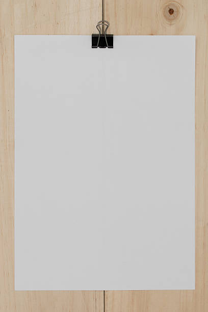 istock white paper with paperclip on wooden background. 531243308