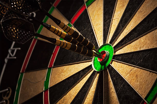 Three darts in bull's eye close up Success hitting target aim goal achievement concept background - three darts in bull's eye close up darts photos stock pictures, royalty-free photos & images
