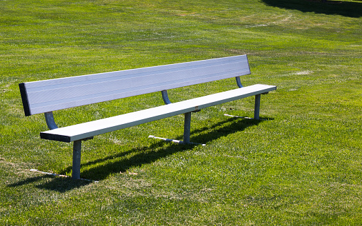 Metal childrens sports bench on a grass baseball or soccer field