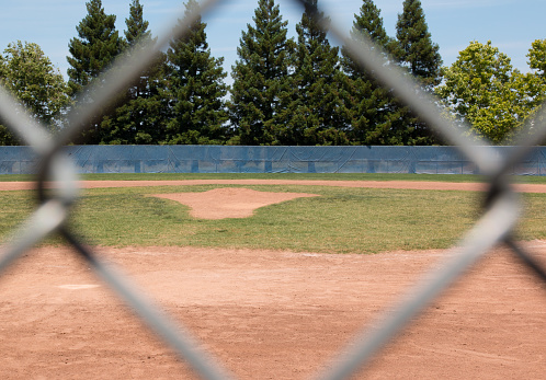Looking at a little league baseball field through a chain link fence