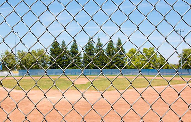 baseballfeld durch zaun - baseball dirt softball baseball diamond stock-fotos und bilder