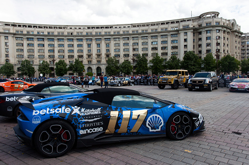 Bucharest, Romania, May 7, 2016: Super cars of the exclusive Gumboil 3000 parked in front of the Romanian Parliament. Gumball is an international celebrity rally which takes place on public roads. with people.