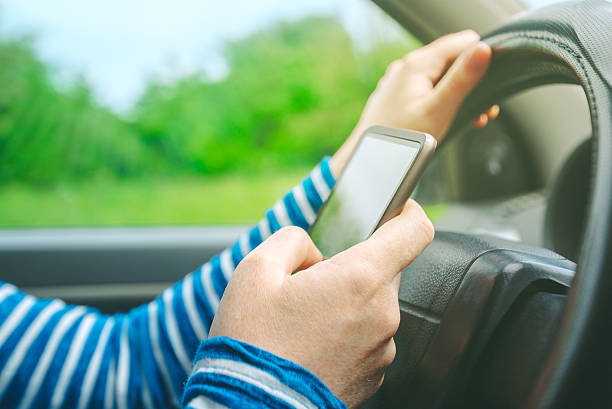 istock Female driving car and texting sms message on smartphone 531247428
