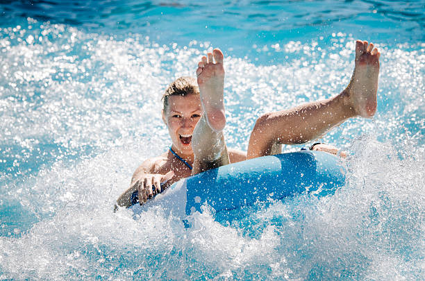 Girl takes a ride at a water park Happy girl taking a fast water ride on a float splashing water. Summer vacation with water park concept. bulgarian culture photos stock pictures, royalty-free photos & images