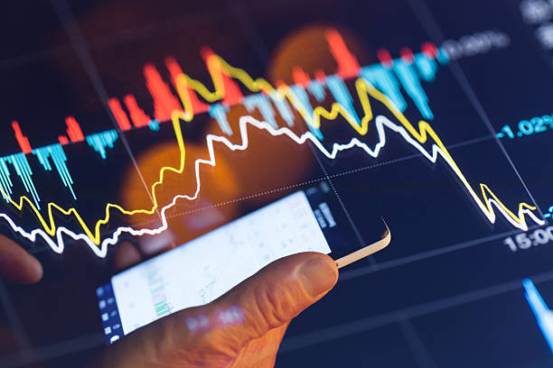 istock man with touch phone illuminated by stock chart 531248902