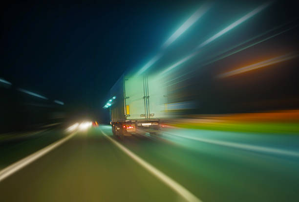 mouvements de camion sur autoroute dans la nuit - traffic blurred motion multiple lane highway night photos et images de collection