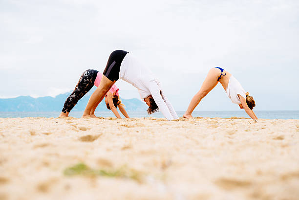 istock Practicing yoga and meditation in summer on beach in sunset 531250668