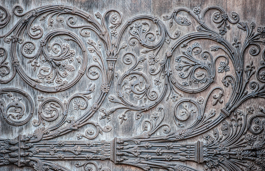 Ornament twirly metal fittings on ancient medieval door. The portal with the doors was constructed between 1210-1220, and the cathedral was restored 1845. The original creator of the artwork is unknown and the copyright long expired. Notre Dame, Paris, France.