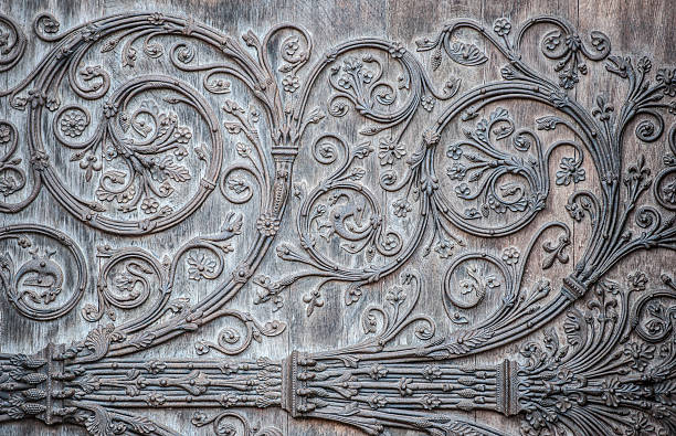 Outside door ornament - Notre Dame, Paris, France Ornament twirly metal fittings on ancient medieval door. The portal with the doors was constructed between 1210-1220, and the cathedral was restored 1845. The original creator of the artwork is unknown and the copyright long expired. Notre Dame, Paris, France. gothic art stock pictures, royalty-free photos & images