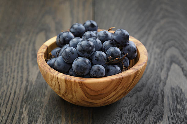 istock ripe isabella grapes in wood bowl on table 531252461