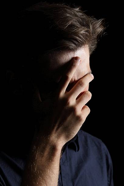 istock Worried or embarrassed man on black 531252981