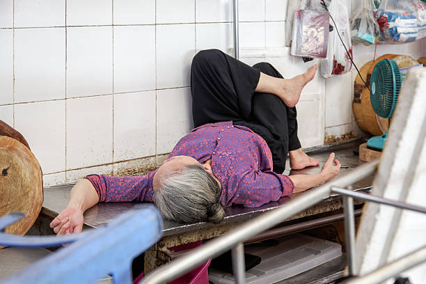 Saigon, Vietnam – January 15, 2015: Old lady sleeping after a hard day’s work in the food market 