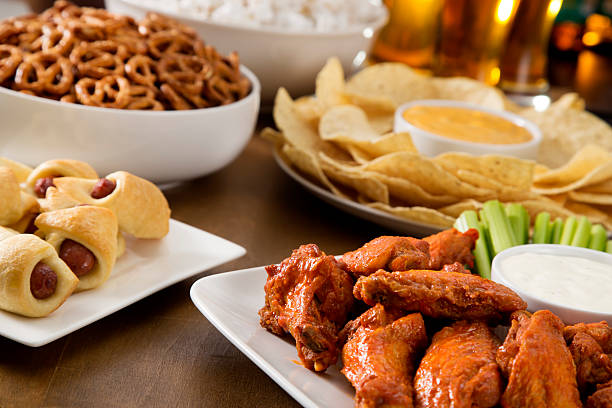 Tailgate food spread Tailgate food - Hot wings, pig in the blankets, pretzels, popcorn, and beer.  Please see my portfolio for other food and drink images.  spread wings stock pictures, royalty-free photos & images