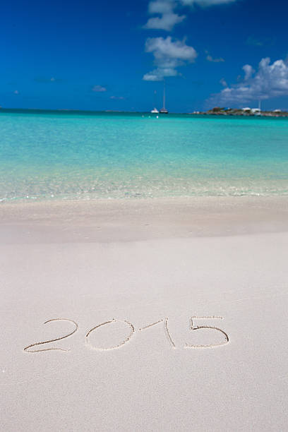 istock Year written on tropical beach white sand with xmas hat 531254441