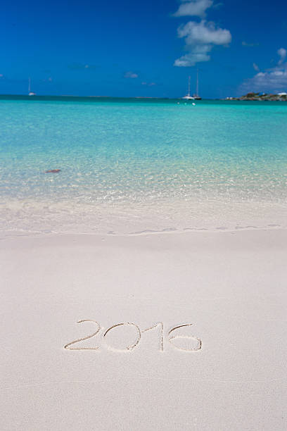 istock Year written on tropical beach white sand with xmas hat 531254465