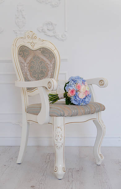 istock Blue flower bouqet lying on white ancient chair 531255226