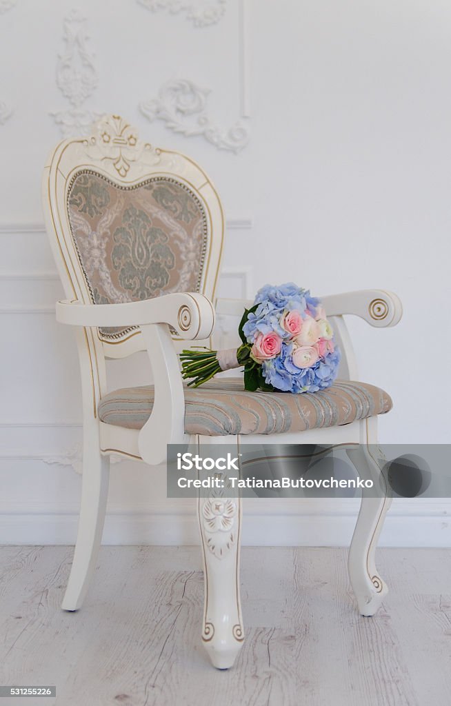 Blue flower bouqet lying on white ancient chair A white antique chair with a blue flower bouqet lying on it Arrangement Stock Photo