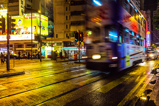 Old tram and pedestrians in Hong Kong at night; business centre, Hong Kong Island, China.