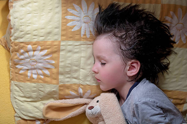 Adorable little boy, sleeping at night with his teddy bear Adorable little boy, sleeping at night with his teddy bear friend toy young hot stock pictures, royalty-free photos & images