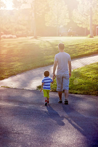 istock Father and son, walking in a park on sunset 531257826
