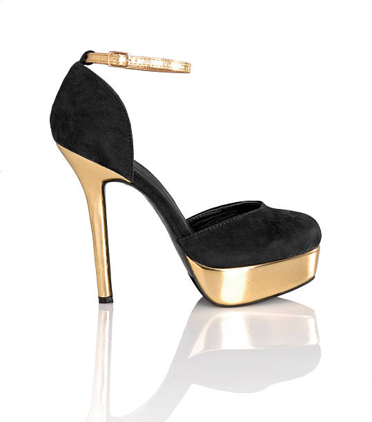 Women's black and gold pumps shoe on a white background stock photo