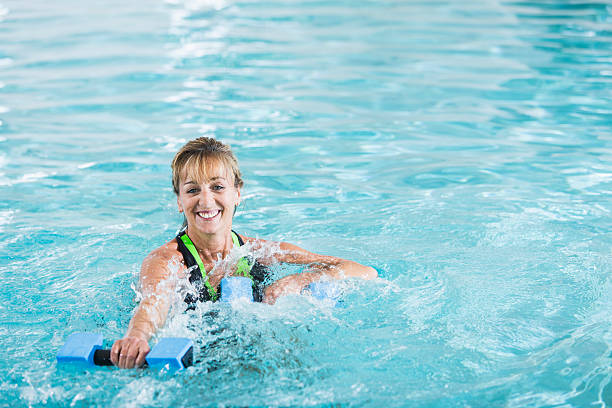 istock Middle-aged  woman in pool doing water aerobics 531262799