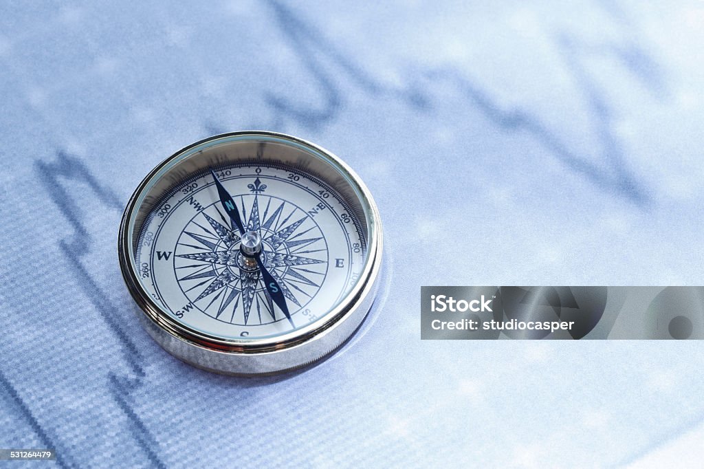 financial analysis Close-up of a compass on stock market data chart  Navigational Compass Stock Photo