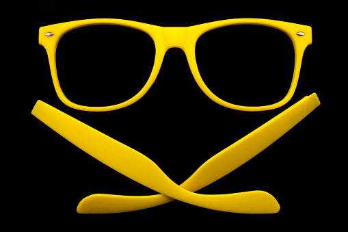 Black plastic framed glasses with detached arms on white background.