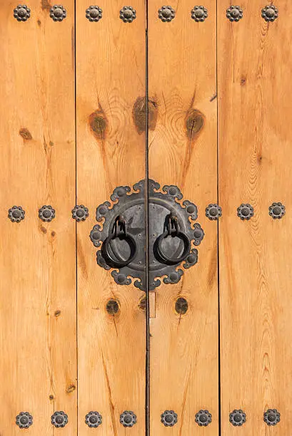 Antique doorhandle on wooden door.