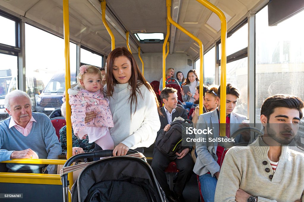 Getting Off the Bus Young mother and her child with pushchair getting off the bus. Bus Stock Photo