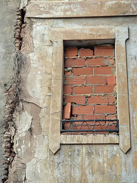 Hasty brickwork to seal the window of an old and crumbling building in Valencia, Spain.