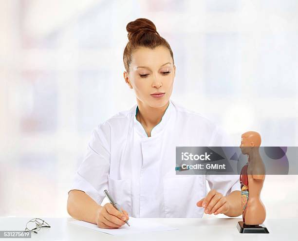 Beautiful Midage Female Doctor Sitting At The Table Stock Photo - Download Image Now