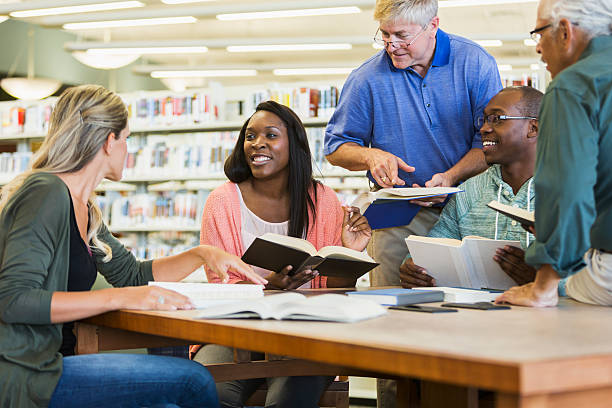 adultes étudiants étudient ensemble dans la bibliothèque - adult student women mature adult library photos et images de collection