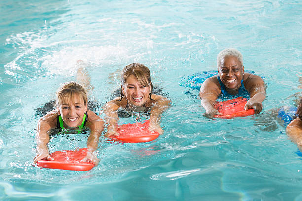 multirracial grupo de mulher na piscina - fun senior adult aerobics exercise class imagens e fotografias de stock