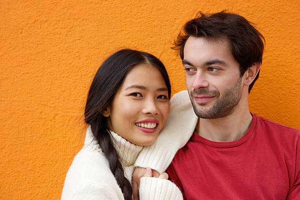 istock Young man and woman posing against orange background 531289131