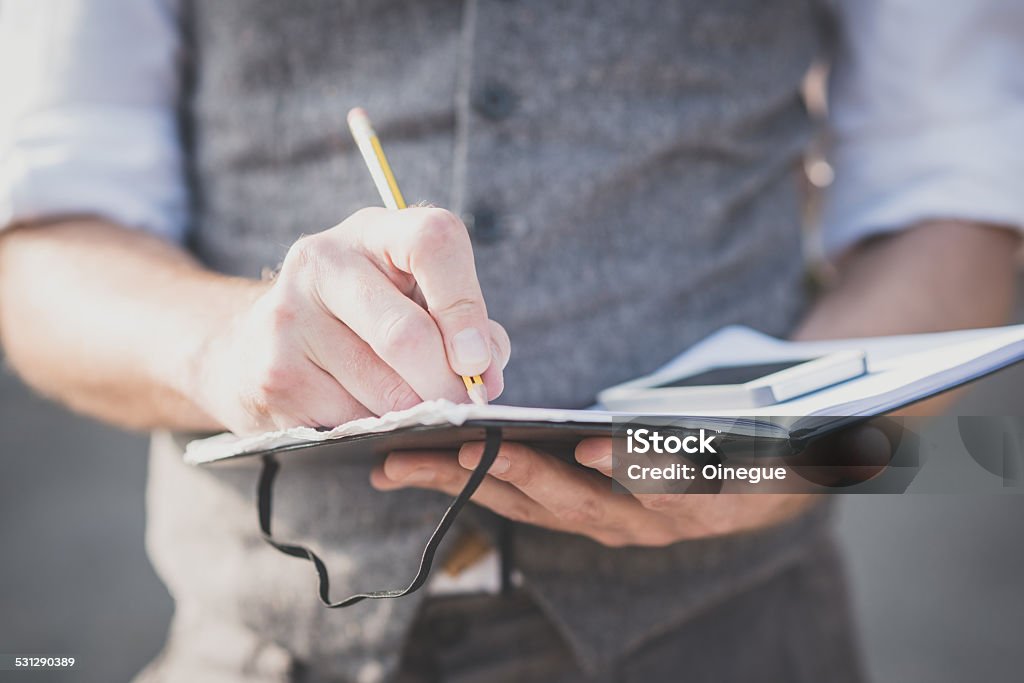 close up hands man writing on diary and smartphone close up hands man writing on diary and smartphone outdoor 2015 Stock Photo