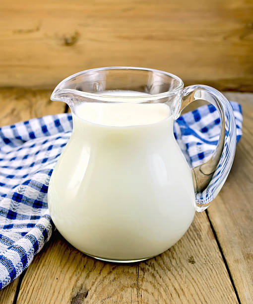 istock Milk in glass jug with napkin on board 531300873