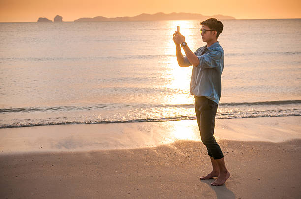 istock Business man working with smartphone beach background 531304158