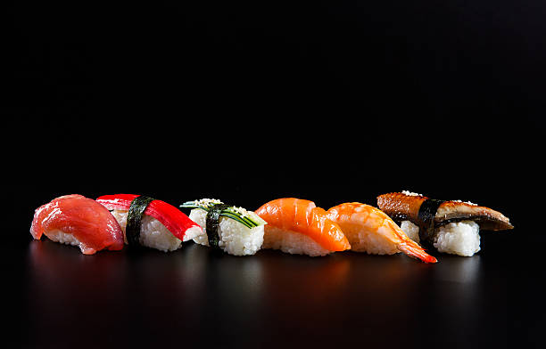 Japanese seafood sushi, on black background Colorful nigiri sushis in a row on black background japanese food stock pictures, royalty-free photos & images