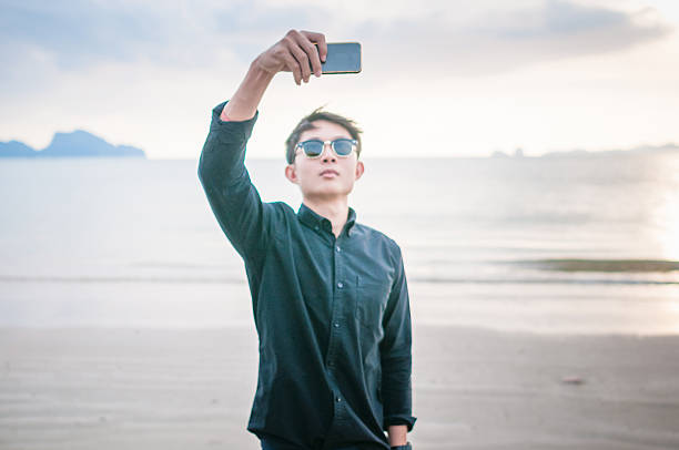 istock Business man working with smartphone beach background 531305406