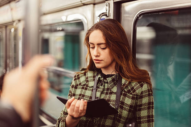 mujer leyendo libro electrónico en el metro - chicas francesas fotografías e imágenes de stock