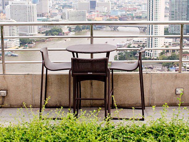 istock Rattan oone table with two stool chairs standing against 531306957