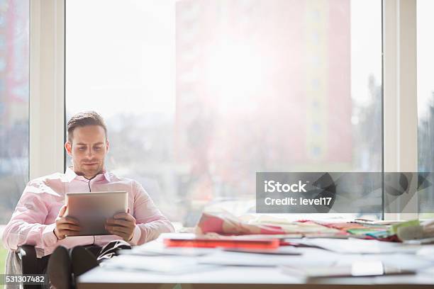 Businessman Using Digital Tablet At Conference Table In Creative Office Stock Photo - Download Image Now