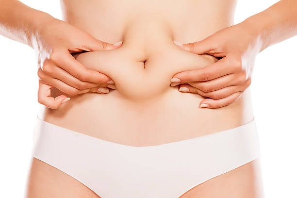 Woman pinching her stomach stock photo