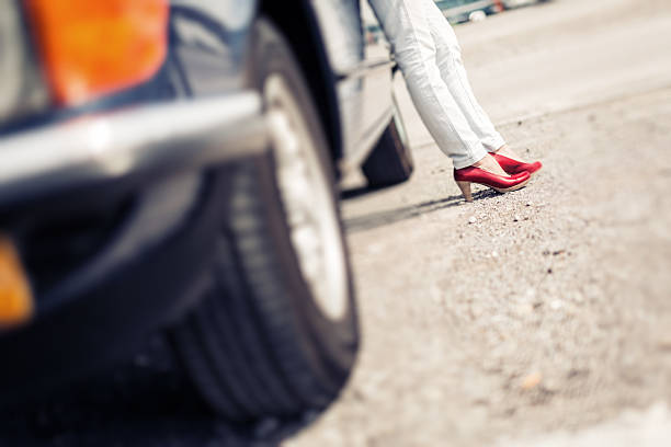 istock woman standing next to convertible classic car 531311018
