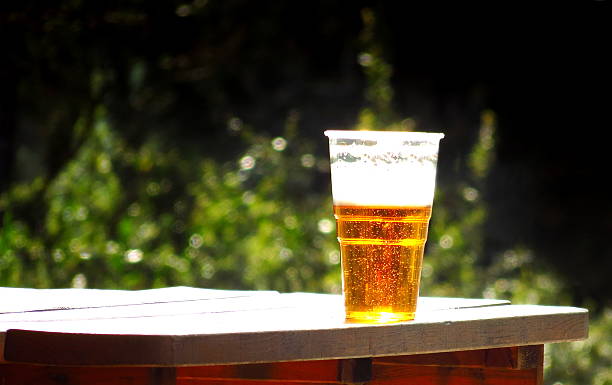 istock plastic cup of beer in nature, background 531314360
